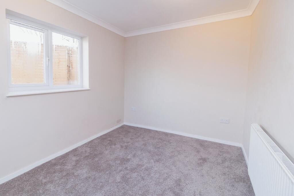 Back bedroom with pale walls and white wood