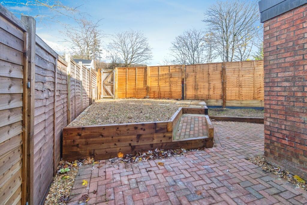 Minimalist garden, with sleepers adding contours and gravel/block paved areas.